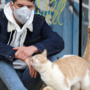 cuidador de gatos vigilando a gato en un jardín